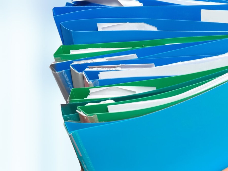 Profissional de saúde carregando pastas de documentos em papel