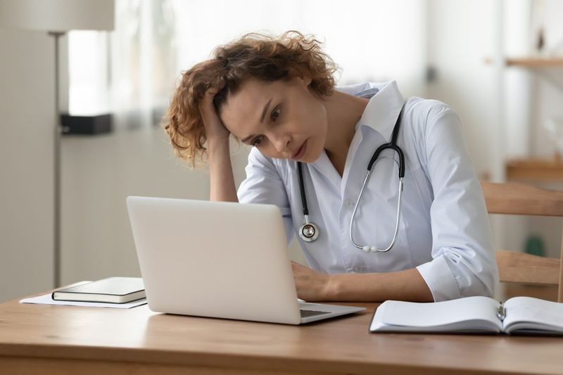 Gestora de home care preocupada diante do notebook
