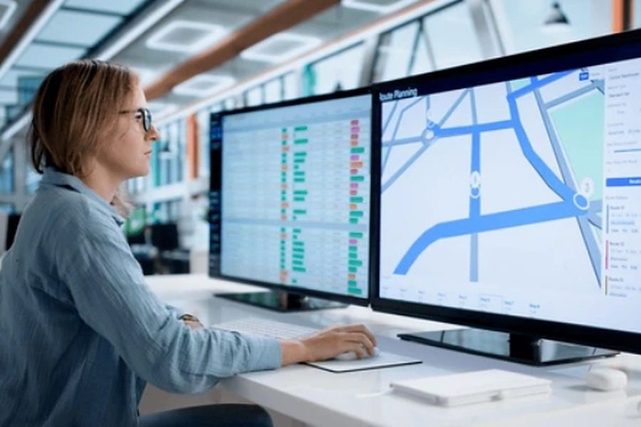 Profissional planejando rotas de entrega em monitores