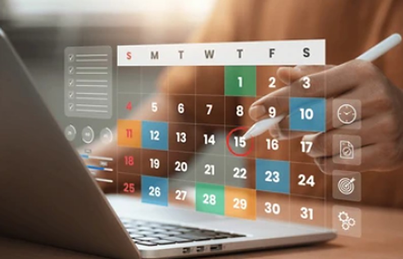 Calendário de escalas em destaque sobre o notebook, com a mão da escalista marcando um dia