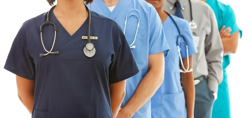 Equipe de profissionais da saúde cooperados, de uniforme e estetoscópio