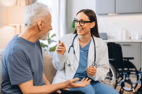 Profissional de saúde conversando com paciente idoso em casa