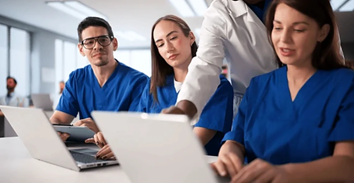 Equipe de enfermagem em capacitação com notebooks